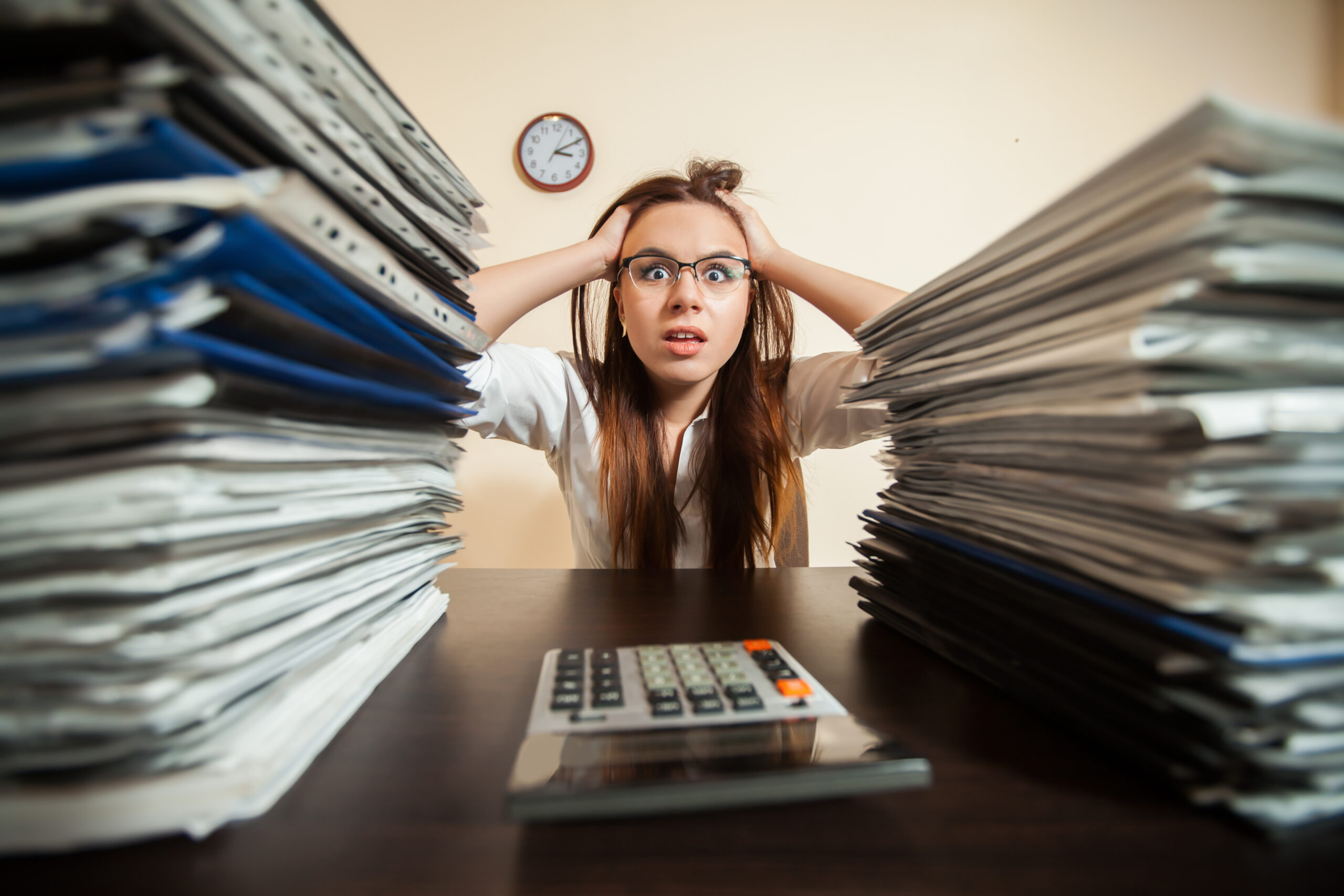 Doomed accountant against big stacks of documents